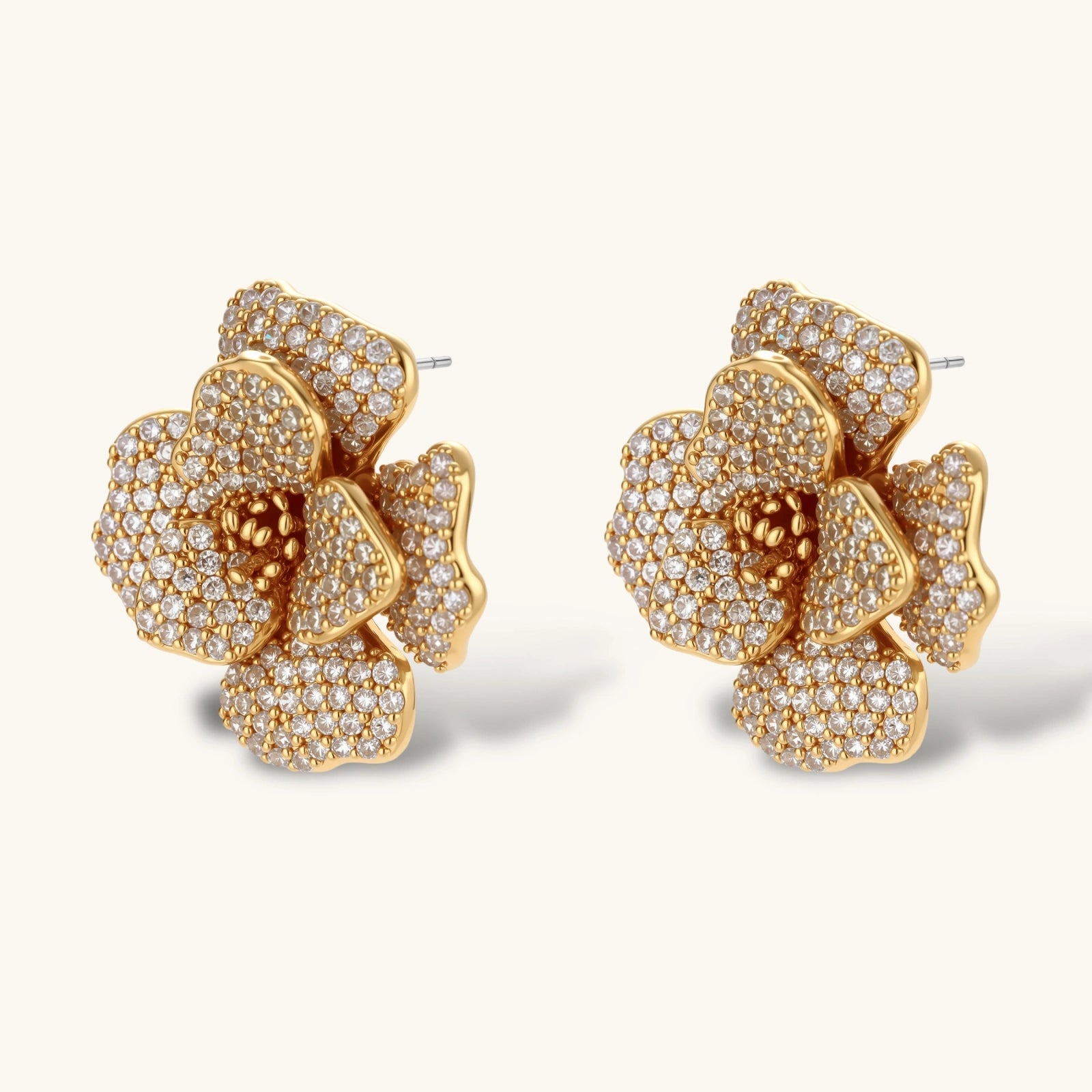 Gold floral earrings with diamond accents on a white background