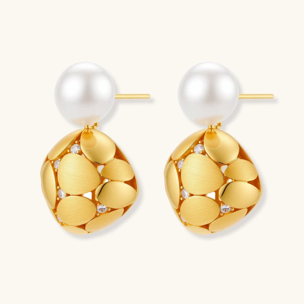 Pair of gold earrings with pearl-like tops on a white background