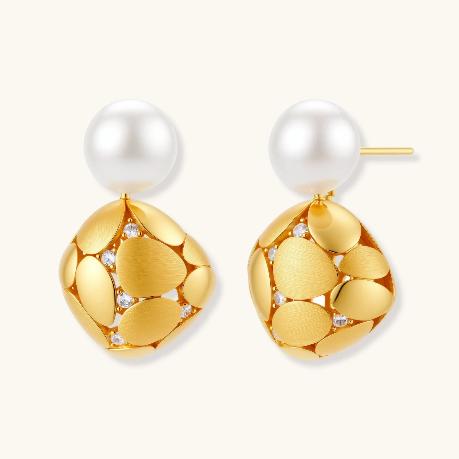 Gold earrings with pearl drops on a white background