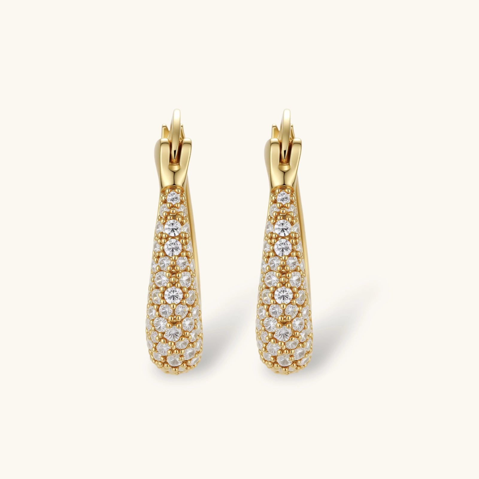 Gold earrings with diamond accents on a white background