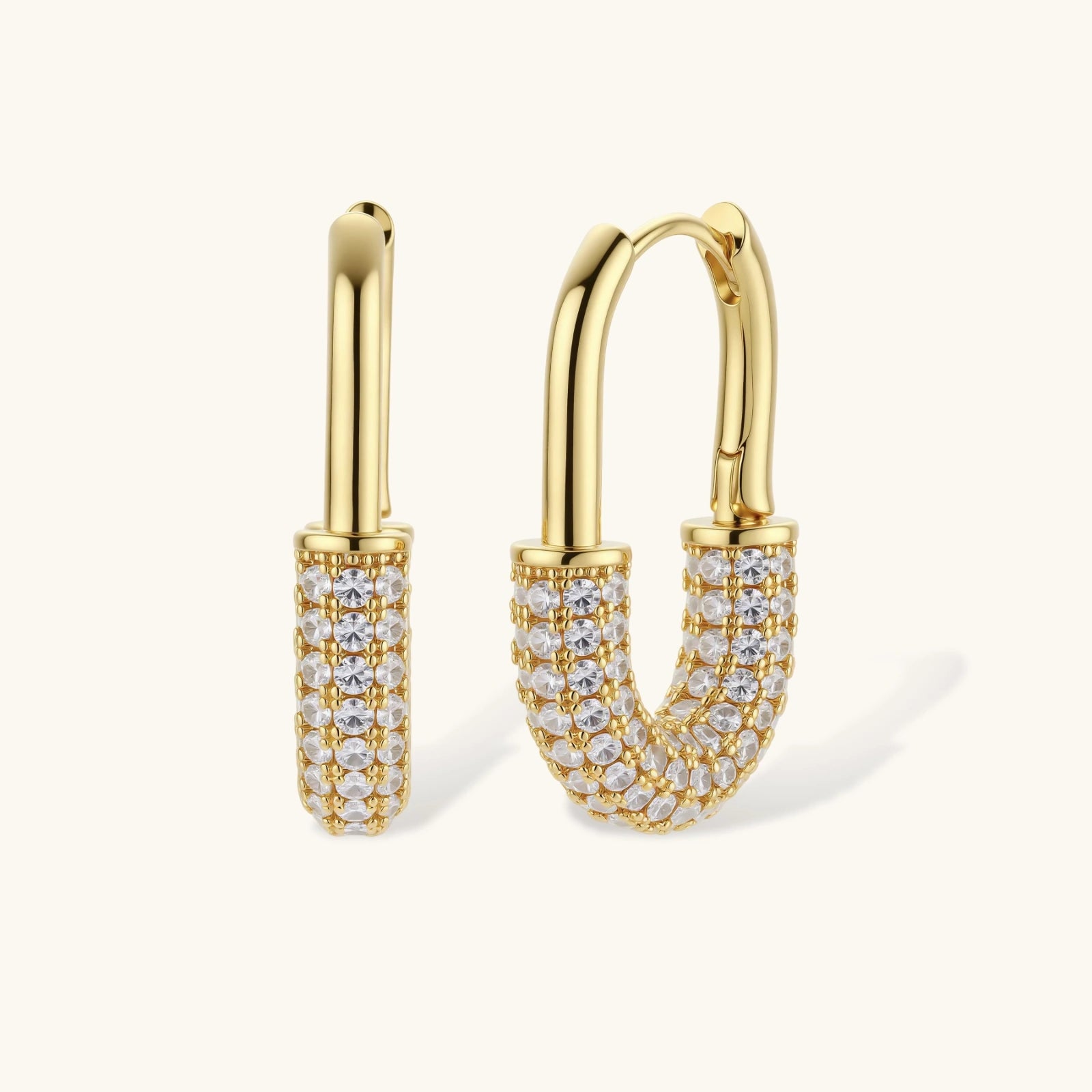 Gold hoop earrings with clear gemstones on a white background