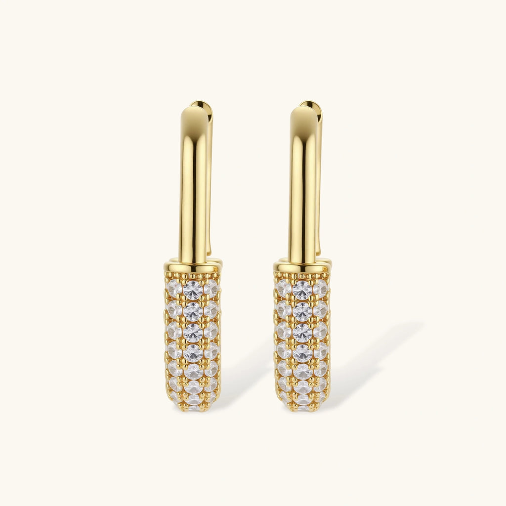 Gold earrings with clear gemstones on a white background