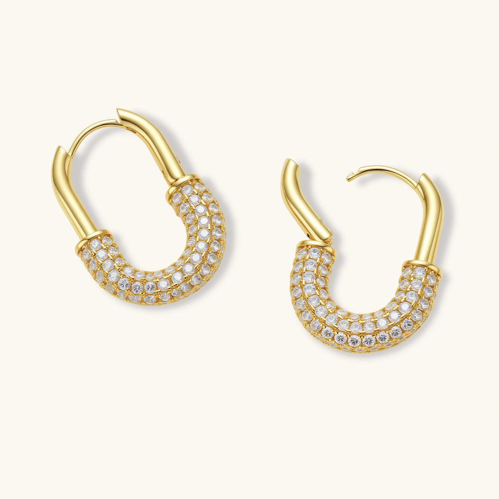 Gold hoop earrings with clear gemstones on a white background
