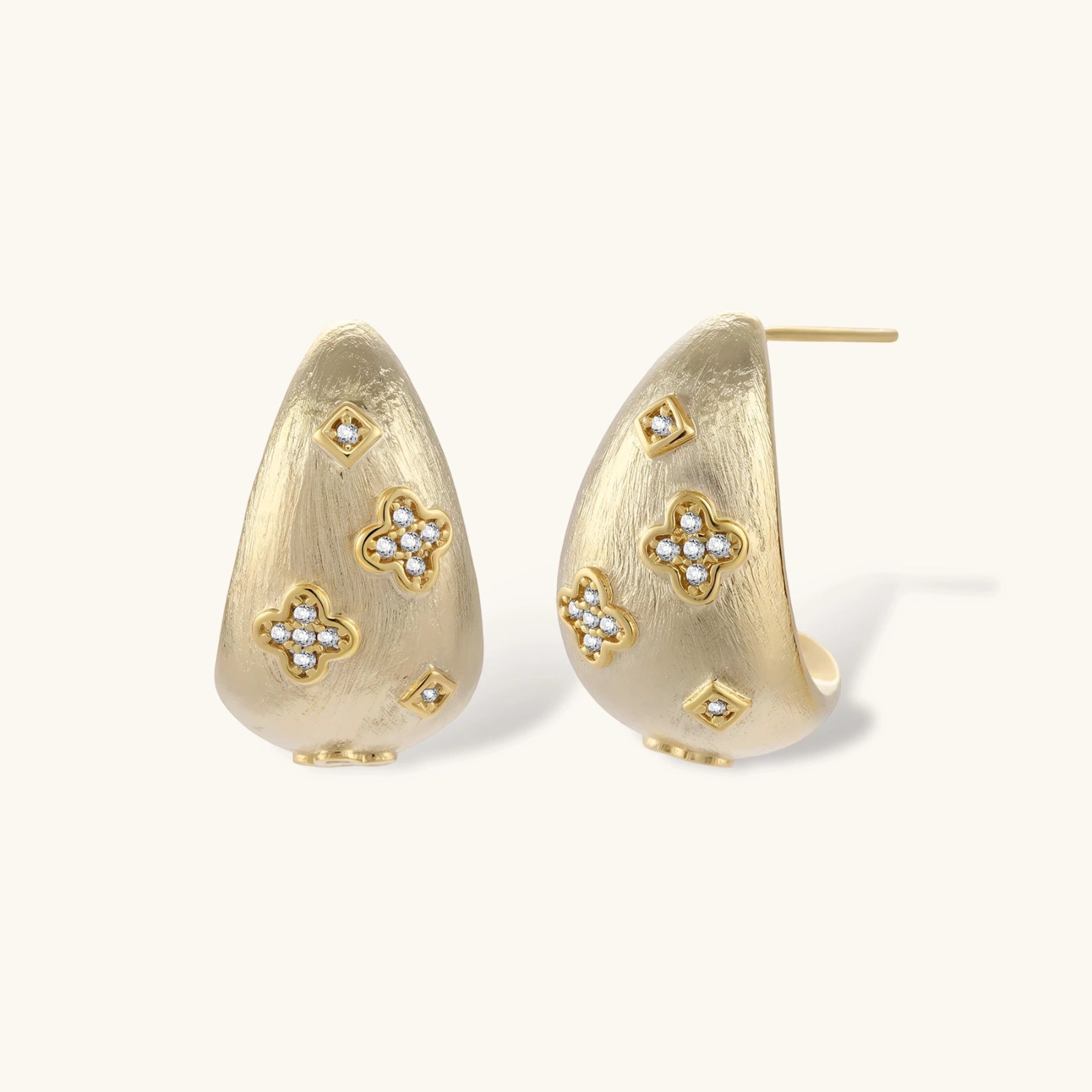 Gold earrings with floral designs on a white background