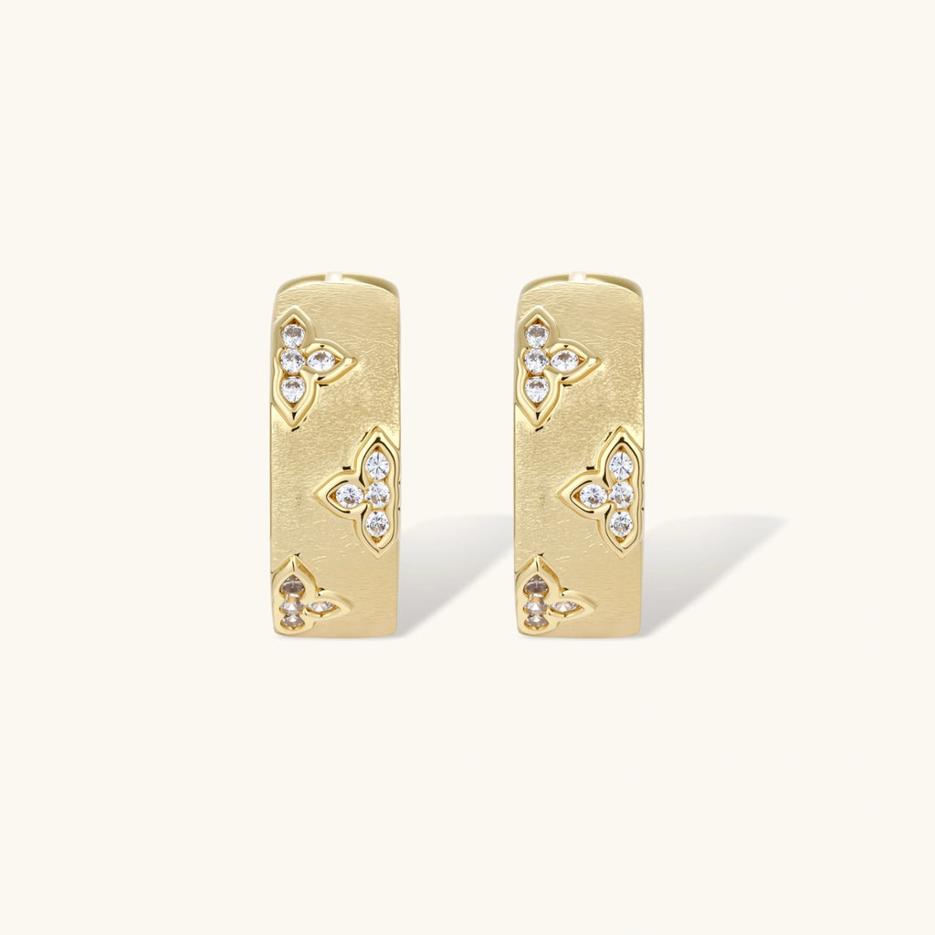 Gold earrings with diamond accents on a white background