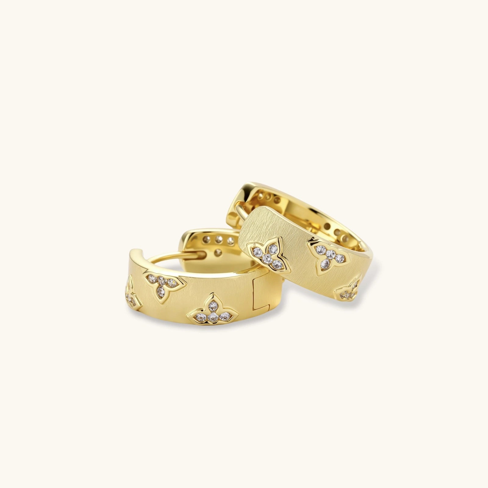 Gold hoop earrings with diamond accents on a white background