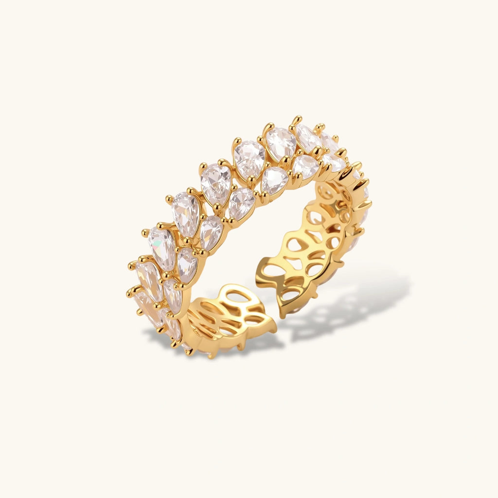 Gold ring with clear gemstones on a white background