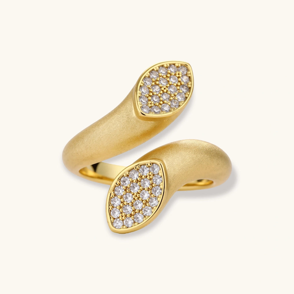 Two gold rings with diamond-studded designs on a white background