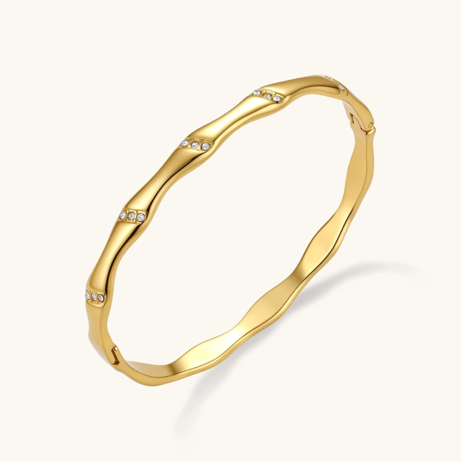 Gold bracelet with small stones on a white background