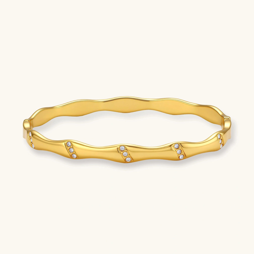Gold bracelet with small stones on a white background
