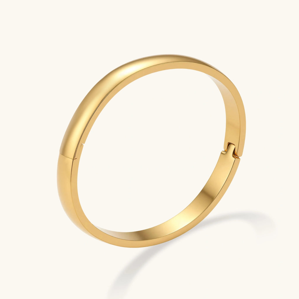 Gold bracelet on a light gray background