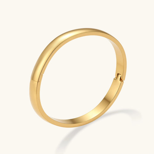 Gold bracelet on a light gray background
