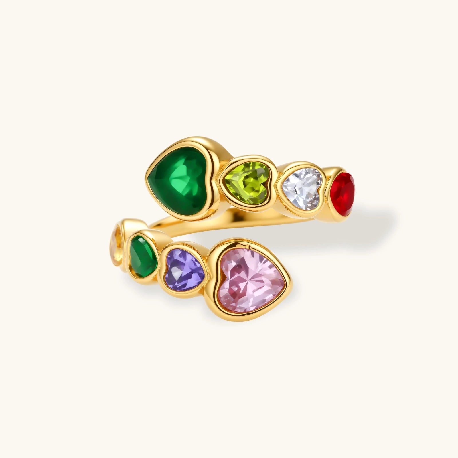 Gold ring with heart-shaped gemstones in various colors on a white background