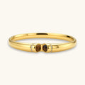 Gold bracelet with two brown gemstones on a white background